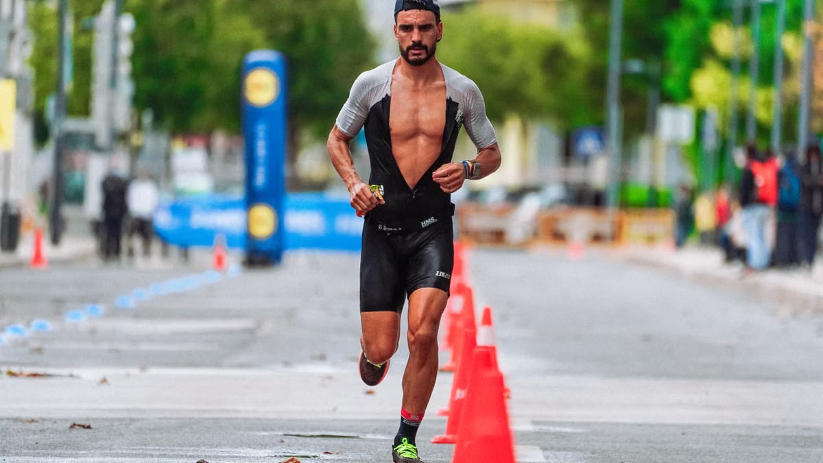 Focused male athlete running a marathon in an urban setting, showcasing endurance and determination.